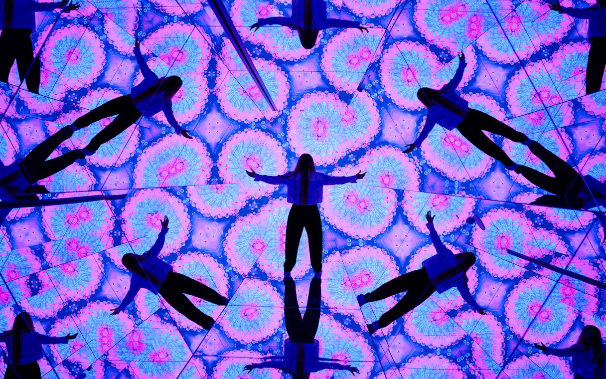 Person surrounded by kaleidoscopic mirrors at House of Hype, Dubai.