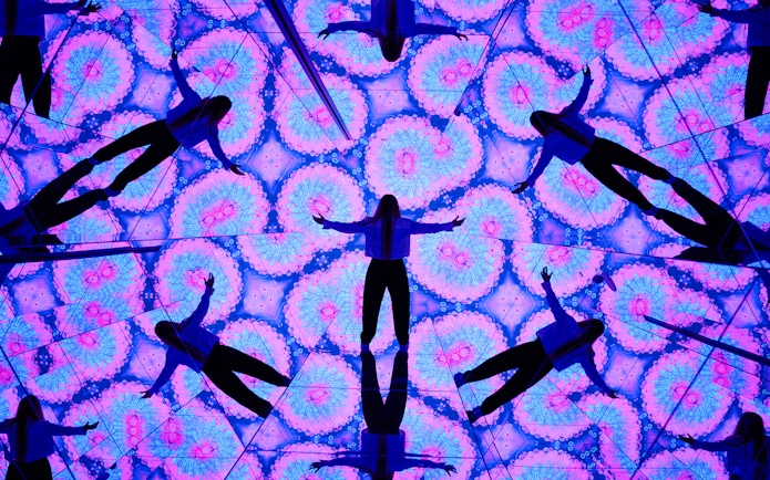 Person surrounded by kaleidoscopic mirrors at House of Hype, Dubai.