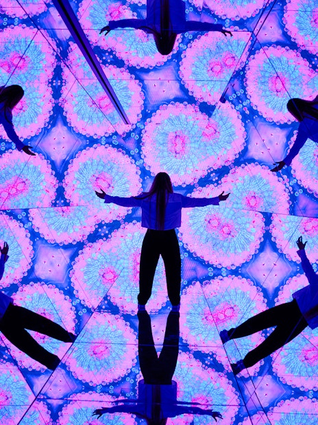 Person surrounded by kaleidoscopic mirrors at House of Hype, Dubai.