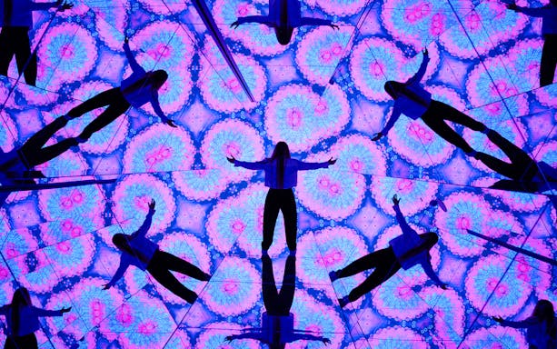 Person surrounded by kaleidoscopic mirrors at House of Hype, Dubai.