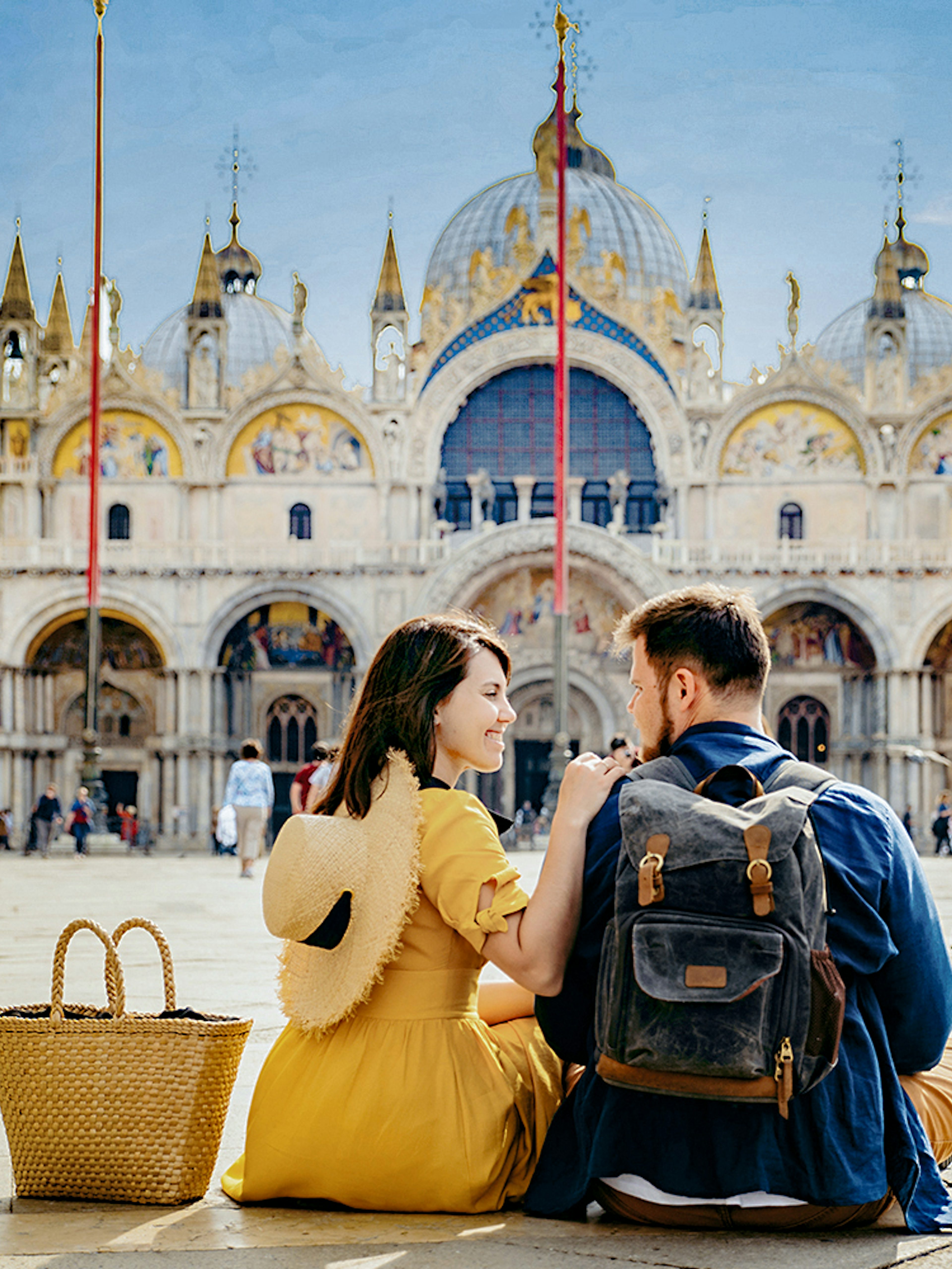 Couple sitting in front of St. Mark's Basilica, Venice, during guided tour with priority entry.