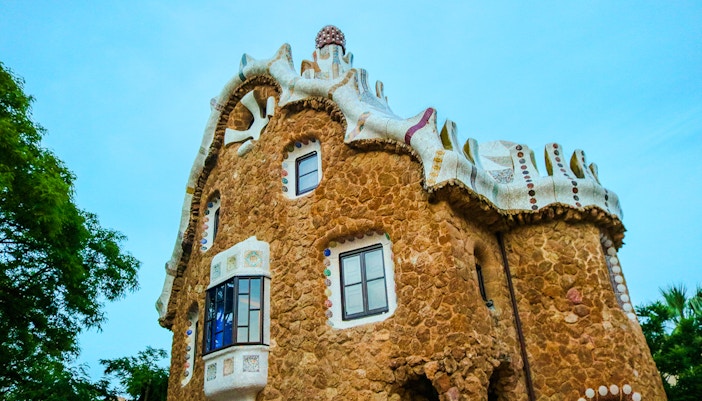 Casa del Guarda in Park Guell, Barcelona, showcasing unique stone architecture and mosaic details.