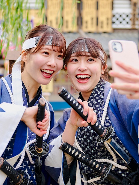 Visitors in samurai costumes taking a selfie at Toei Kyoto Studio Park.