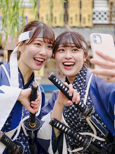 Visitors in samurai costumes taking a selfie at Toei Kyoto Studio Park.