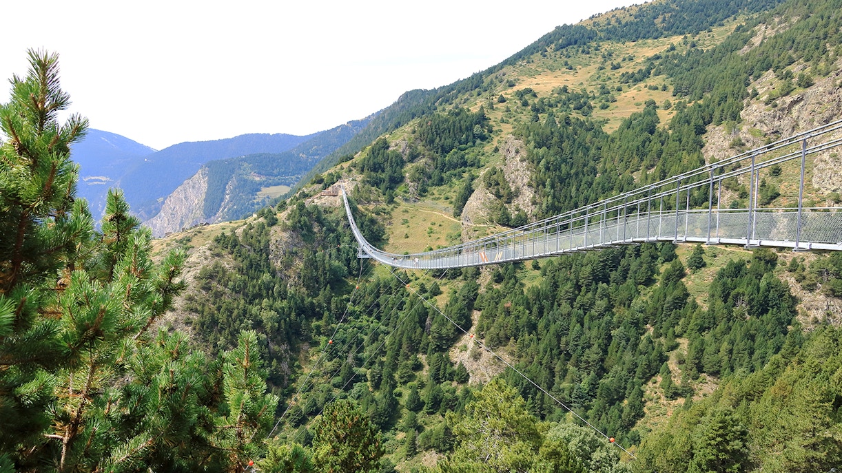 Tibetan Bridge in Andorra spanning a lush green valley with mountain views.