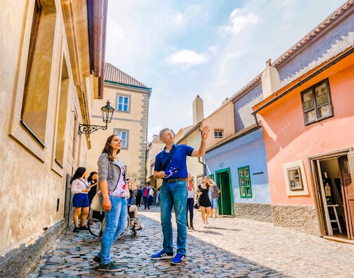 Prague Castle with tourists exploring Golden Lane during a guided tour.