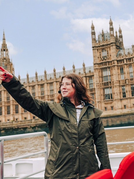 Guests and guide on Tower of London Cruise boat with Houses of Parliament in background.