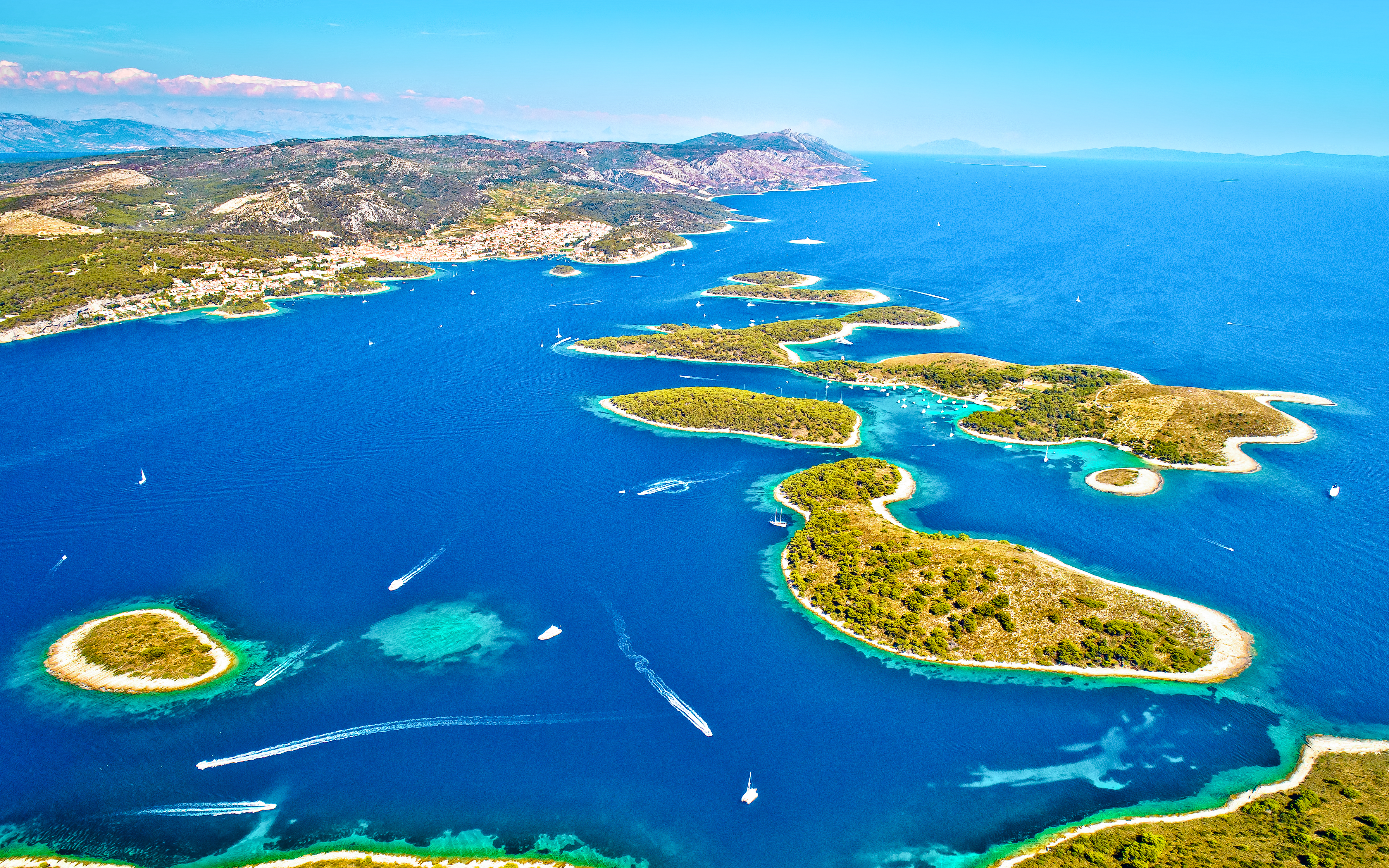 Aerial view of Paklinski Islands, Croatia, with boats navigating between lush green islets.