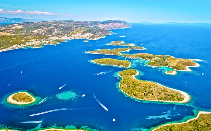 Aerial view of Paklinski Islands, Croatia, with boats navigating between lush green islets.
