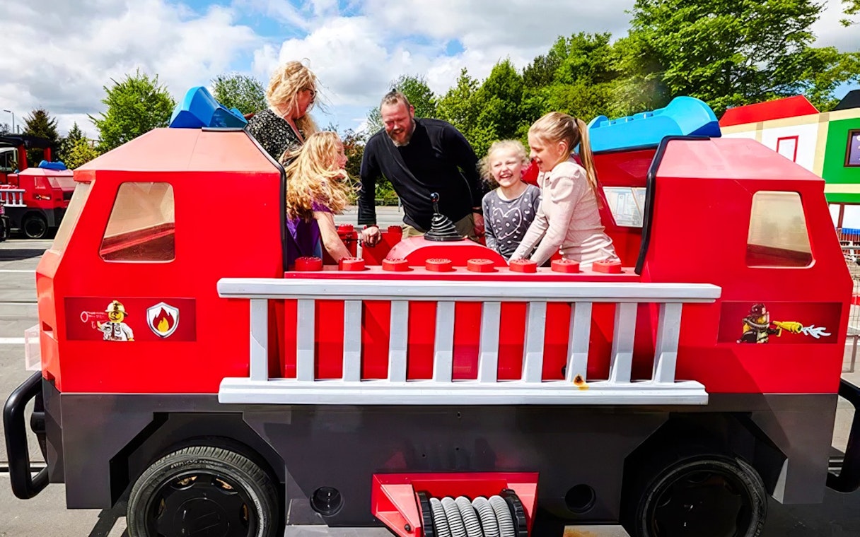 Guests enjoying a fire truck ride at LEGOLAND Billund.