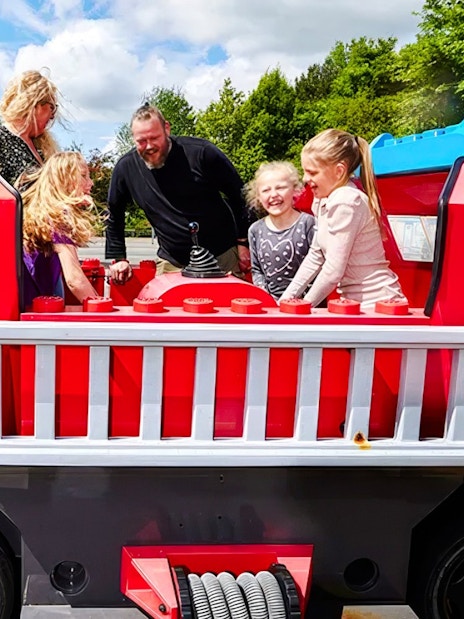 Guests enjoying a fire truck ride at LEGOLAND Billund.
