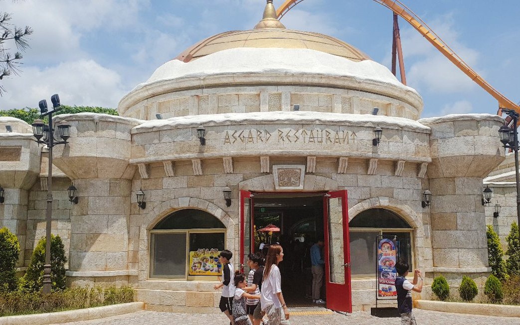 Asgard Restaurant entrance at Gyeongju World, South Korea, with visitors walking in.