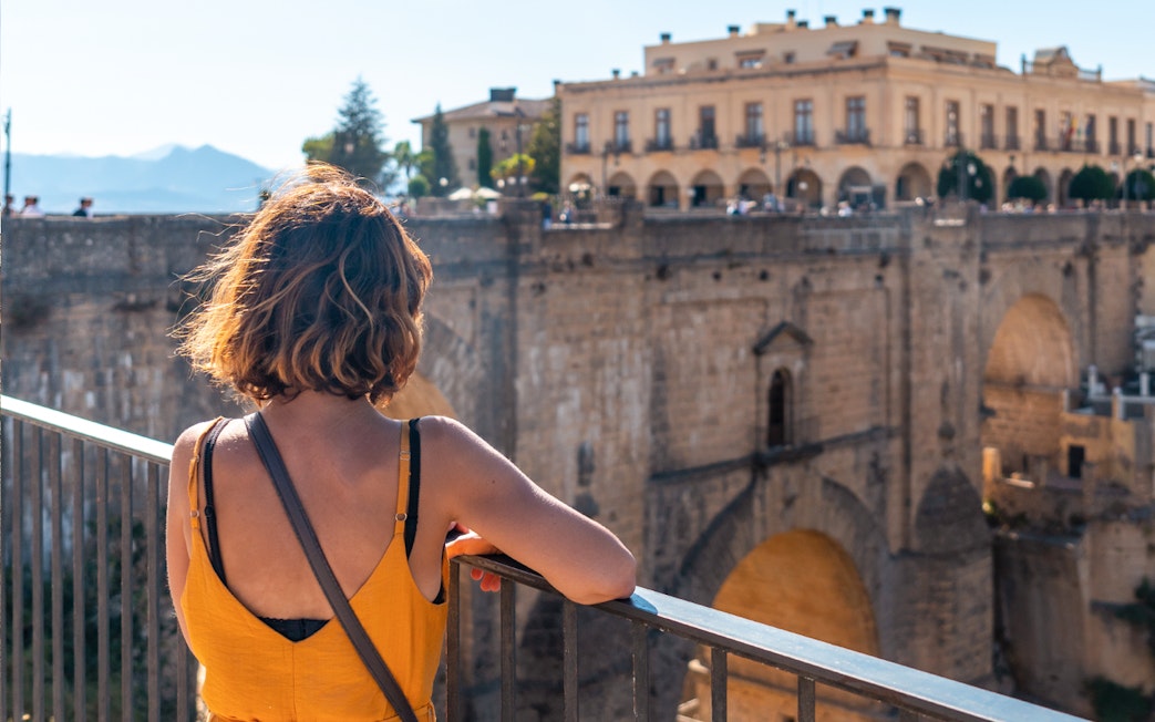 Woman overlooking Puente Nuevo bridge in Ronda during guided tour of Setenil de las Bodegas and Ronda.