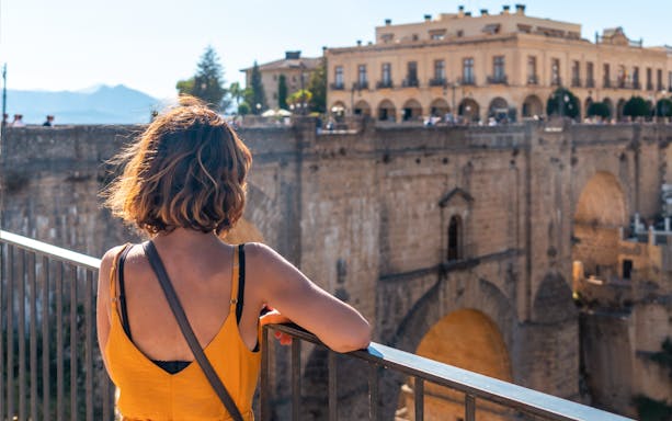 Woman overlooking Puente Nuevo bridge in Ronda during guided tour of Setenil de las Bodegas and Ronda.