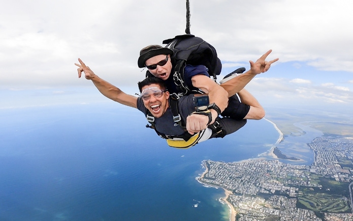 Tandem skydive over Sunshine Coast with beach landing in view.