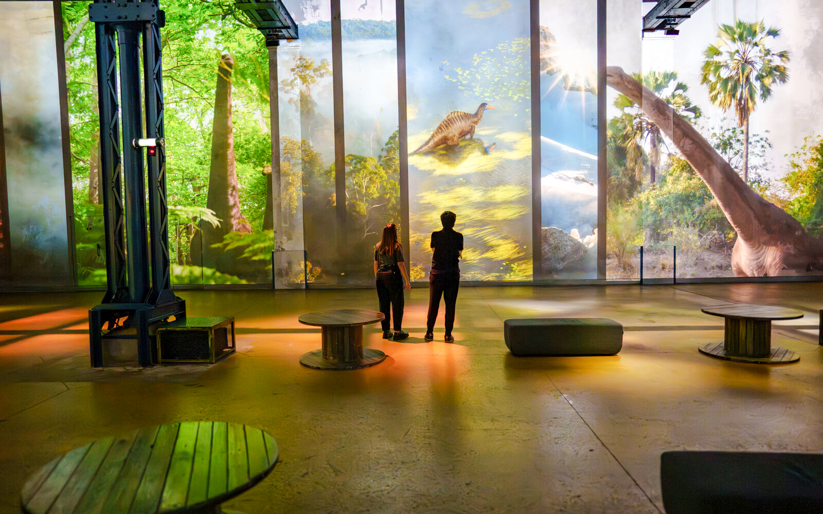 Visitors viewing dinosaur projections at Prehistoric Planet exhibition, Atelier des Lumières.