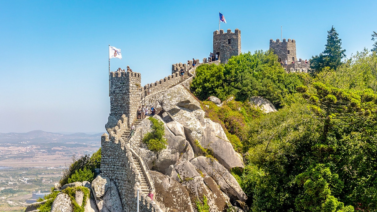Moorish Castle atop a hill with Sintra's green landscape in Portugal.