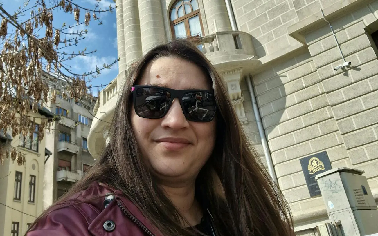 Selfie in front of historic building during Bucharest city exploration game.