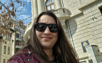 Selfie in front of historic building during Bucharest city exploration game.