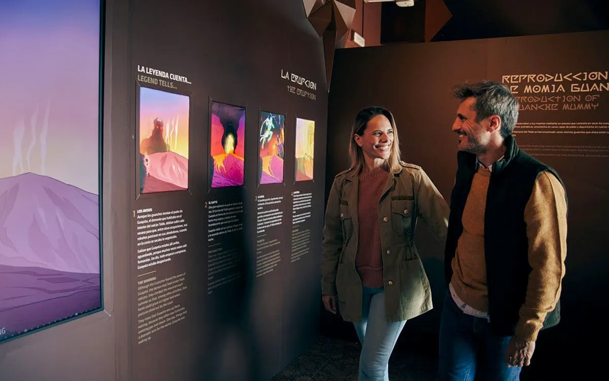 Visitors exploring "Science and Legend" exhibition on Mount Teide's volcanic history and Guanche stories in Tenerife.