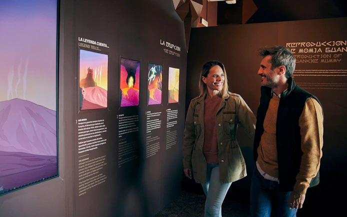 Visitors exploring "Science and Legend" exhibition on Mount Teide's volcanic history and Guanche stories in Tenerife.