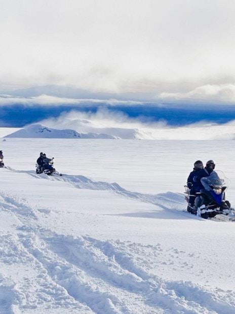 Guests snowmobiling from Gullfoss waterfall across snowy Icelandic landscape.