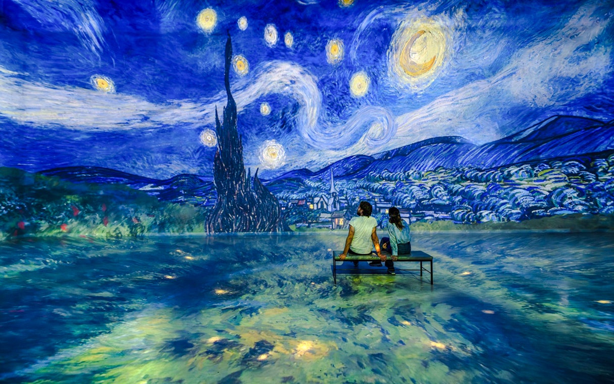 Guests viewing Van Gogh's 'Starry Night' at Frameless London exhibit.