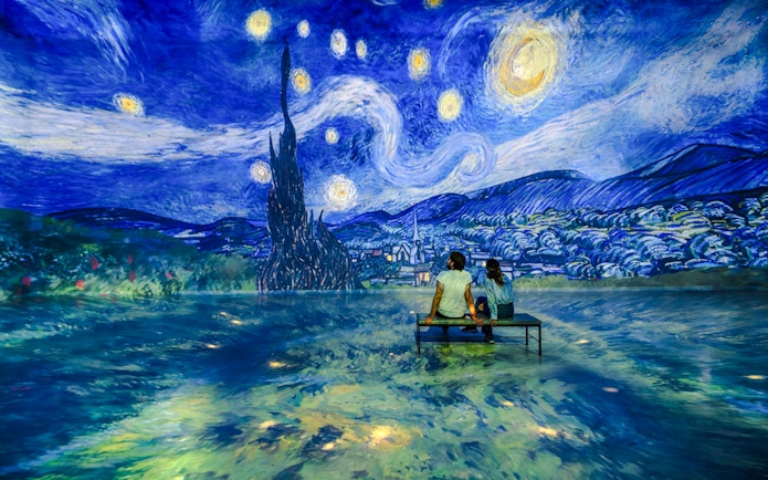 Guests viewing Van Gogh's 'Starry Night' at Frameless London exhibit.