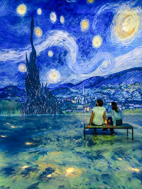 Guests viewing Van Gogh's 'Starry Night' at Frameless London exhibit.