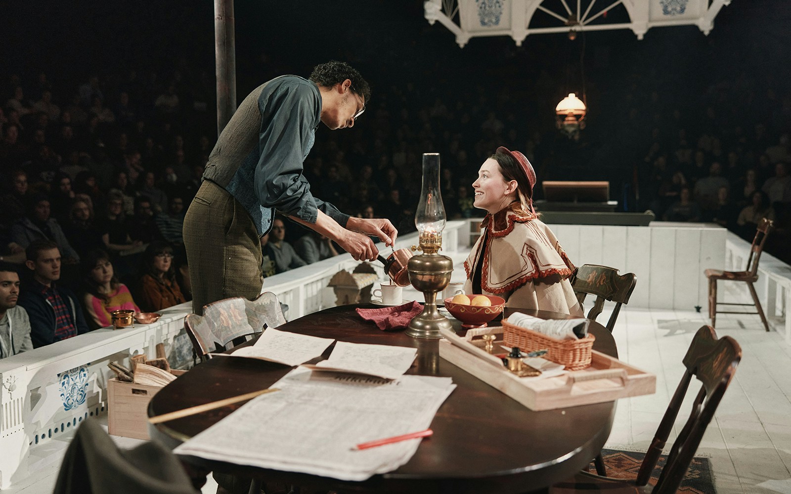 Theater performance of "An Enemy of the People" with actors in period costumes on stage.