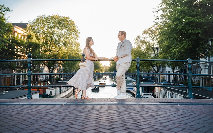 Couple posing on Magere Brug in Amsterdam during a professional photoshoot.