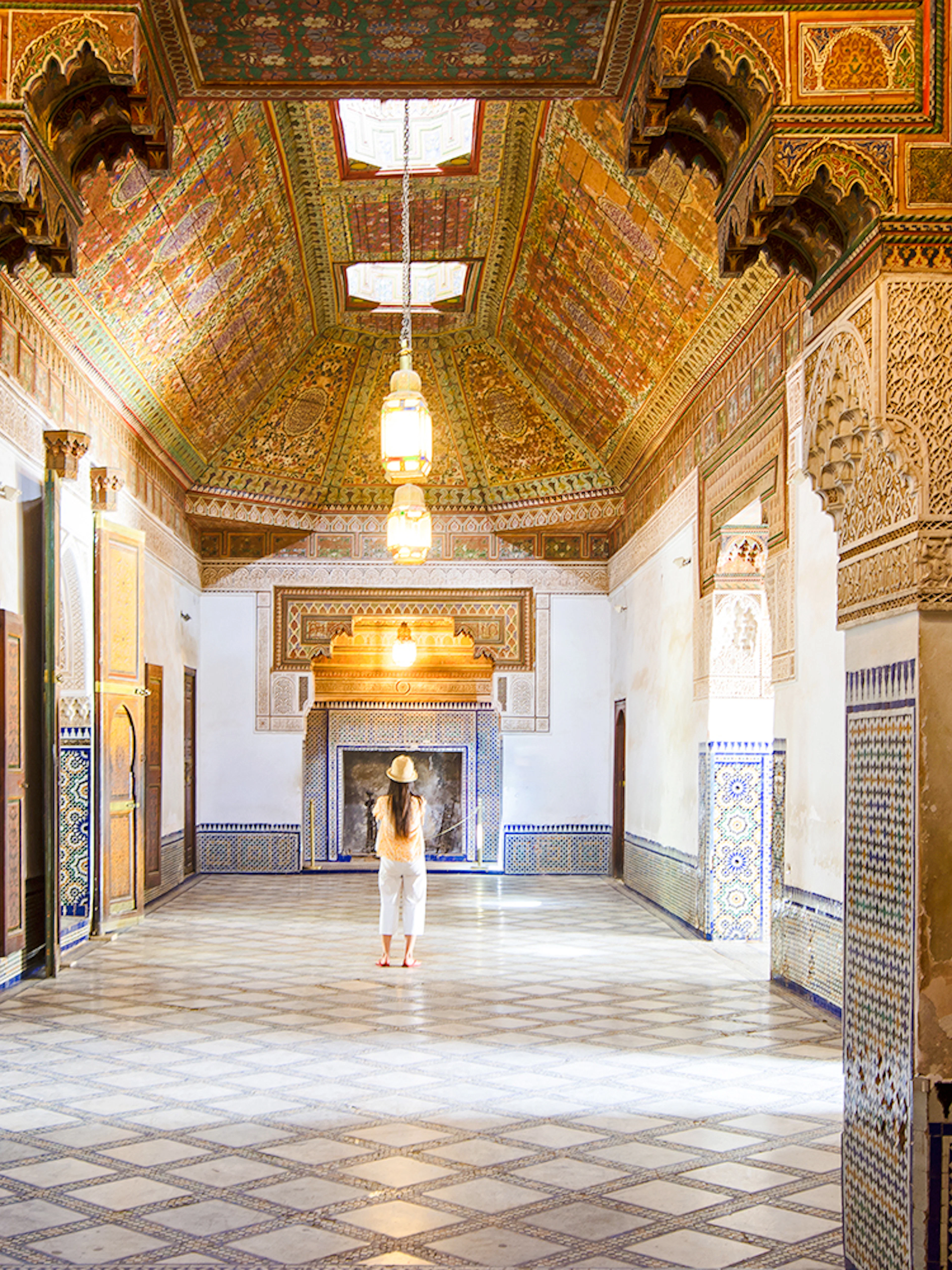 Intricate interior of Bahia Palace in Marrakech, Morocco, with colorful tiles and ornate ceiling.