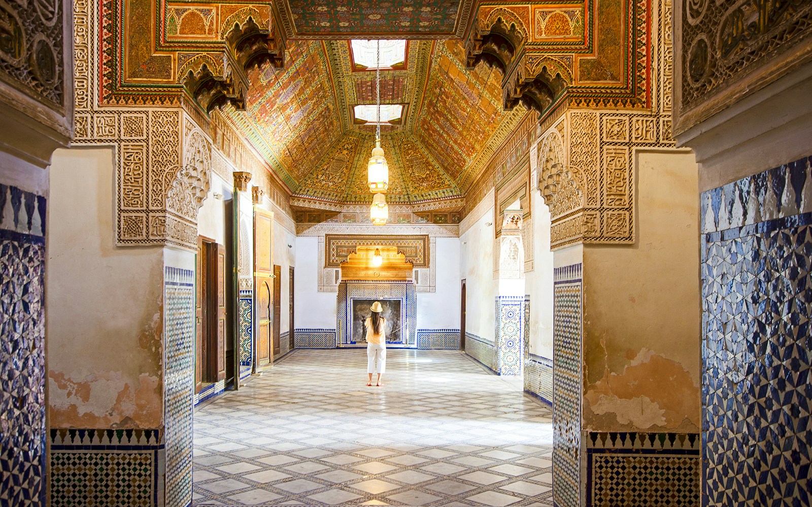 Intricate interior of Bahia Palace in Marrakech, Morocco, with colorful tiles and ornate ceiling.