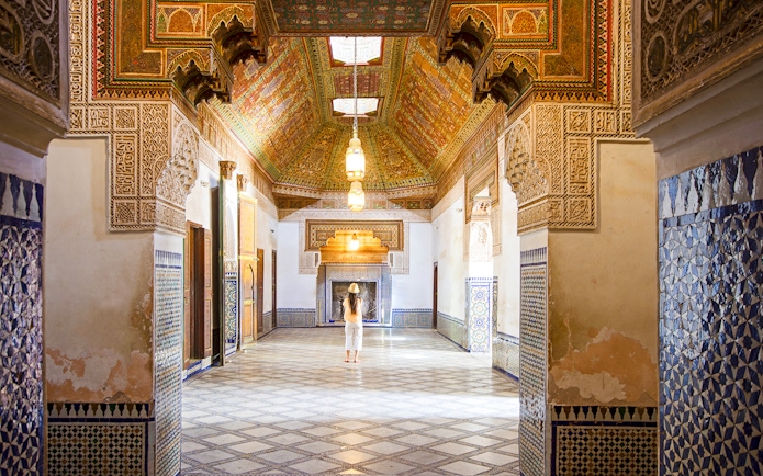Intricate interior of Bahia Palace in Marrakech, Morocco, with colorful tiles and ornate ceiling.