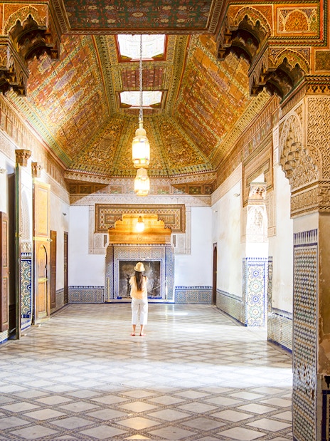 Intricate interior of Bahia Palace in Marrakech, Morocco, with colorful tiles and ornate ceiling.