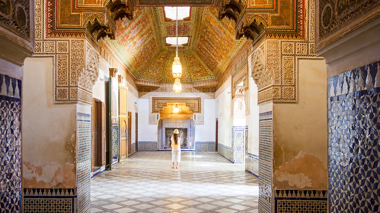 Intricate interior of Bahia Palace in Marrakech, Morocco, with colorful tiles and ornate ceiling.
