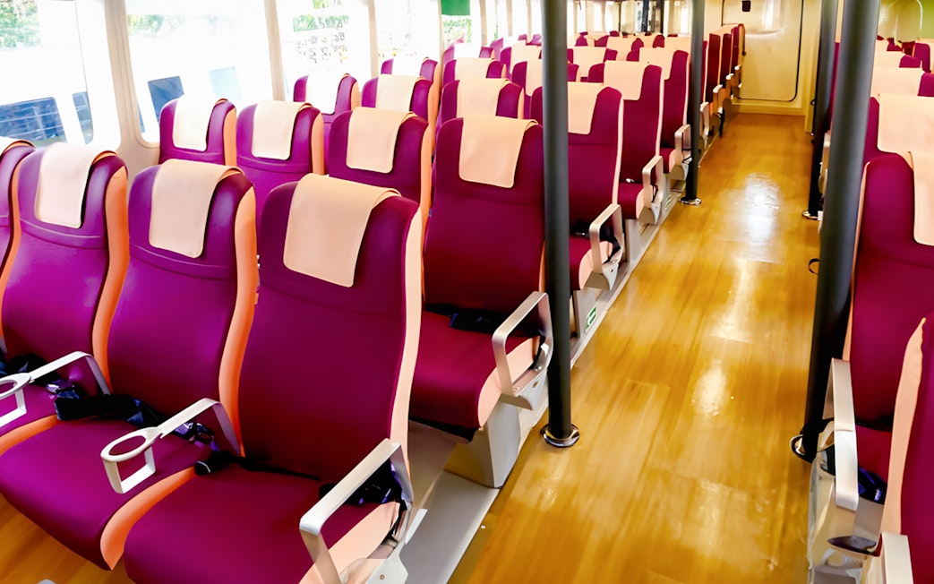 Ferry seating area with rows of red seats at Tanah Merah Terminal for Sindo Ferry tickets.
