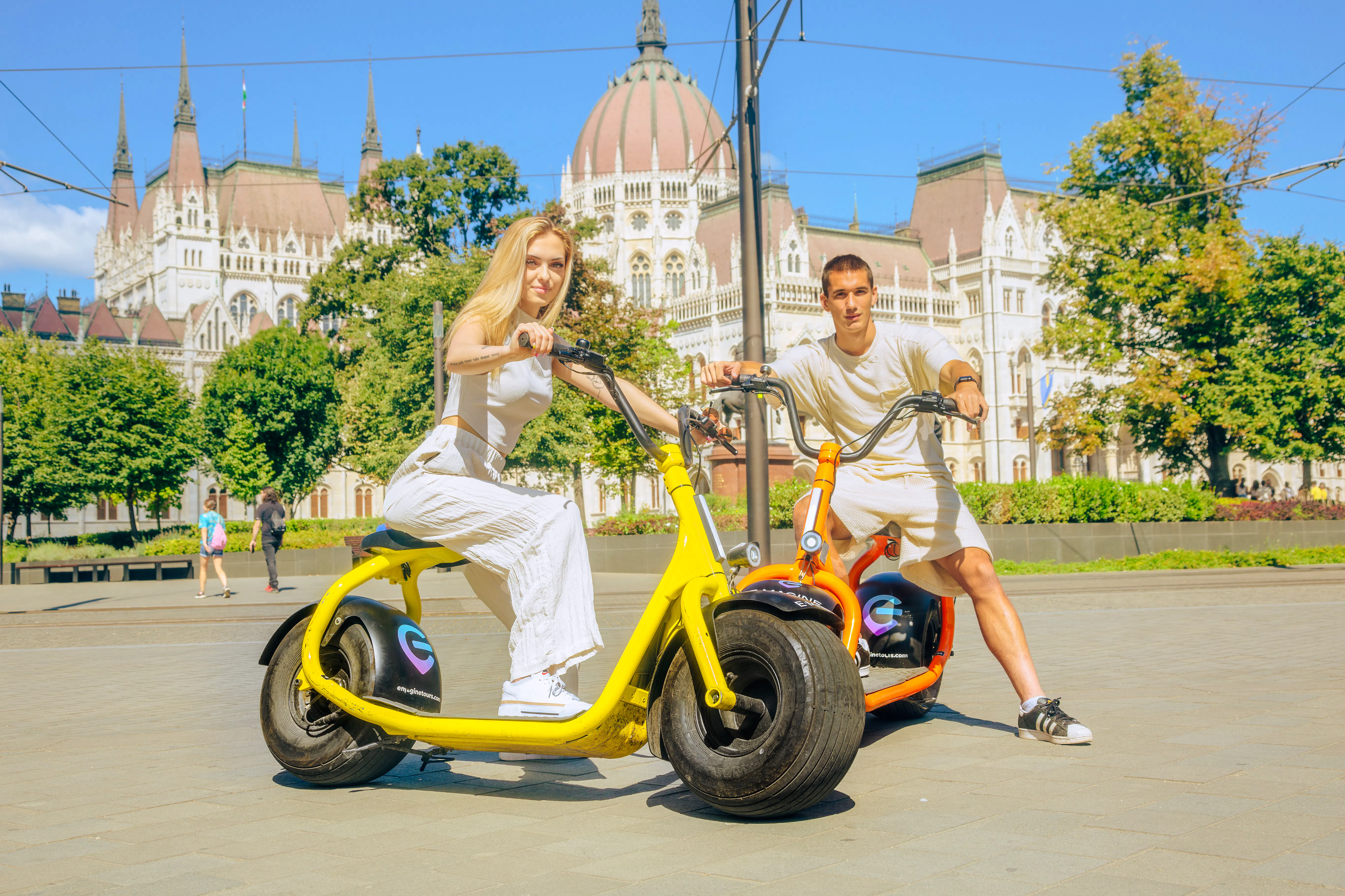 E-scooter riders in front of the Hungarian Parliament Building, Budapest.