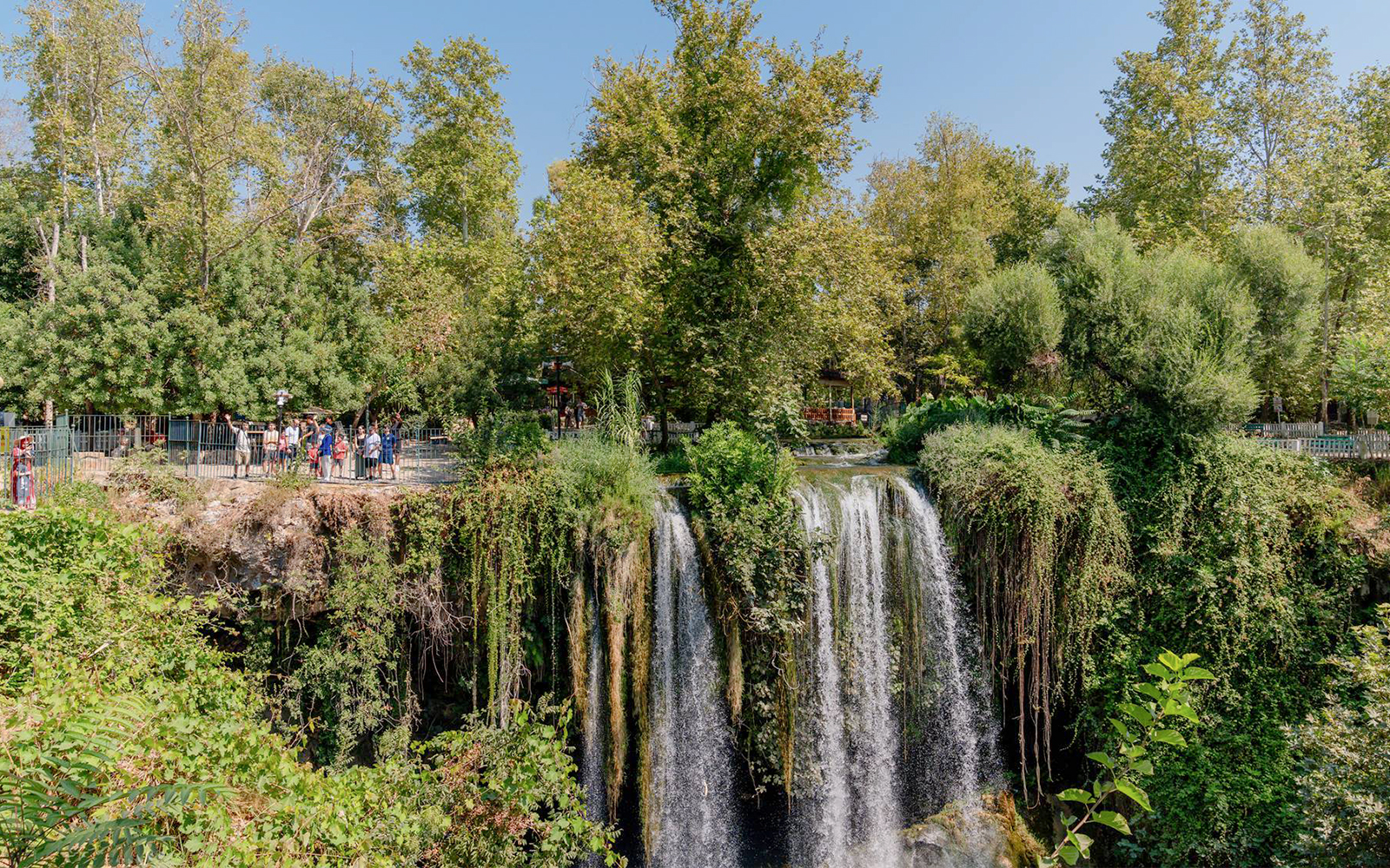 Waterfall surrounded by lush greenery in Antalya during a sightseeing city tour.