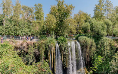 Waterfall surrounded by lush greenery in Antalya during a sightseeing city tour.