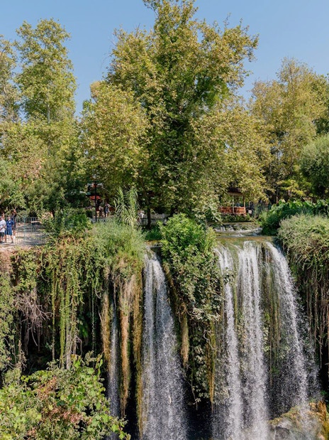 Waterfall surrounded by lush greenery in Antalya during a sightseeing city tour.