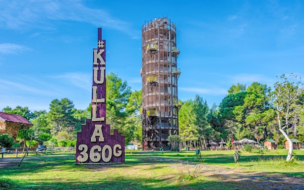 Panorama tower Kulla in Karavasta Lagoon, Albania surrounded by trees.