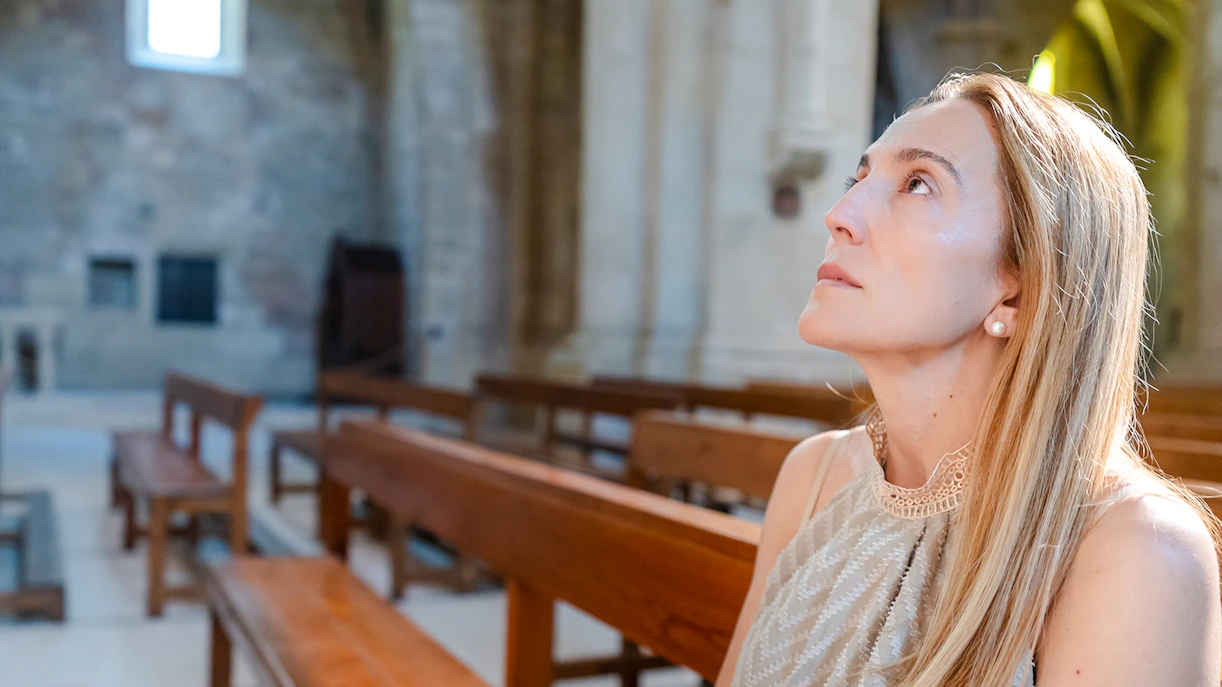 Visitor seated inside Christ the Redeemer Church chapel, looking upwards.