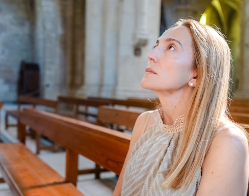 Visitor seated inside Christ the Redeemer Church chapel, looking upwards.