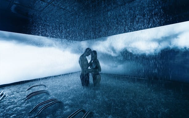 Couple enjoying a rain shower experience at QC Terme Milano spa.