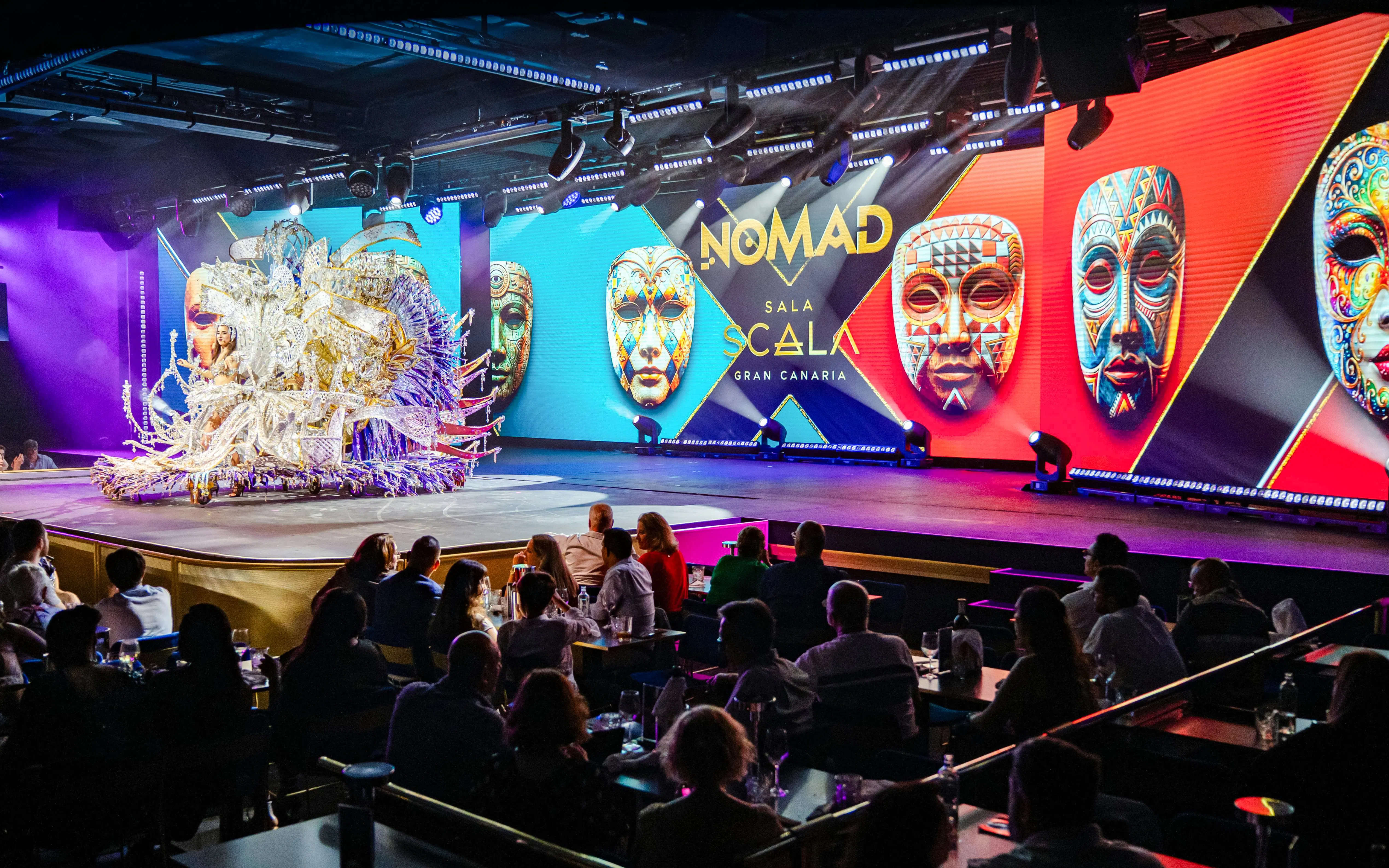 Performance at Sala Scala Gran Canaria with colorful masks and audience.