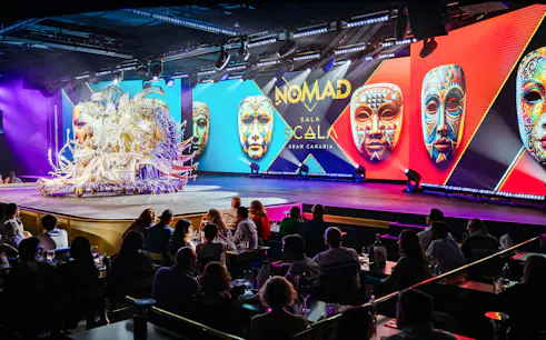 Performance at Sala Scala Gran Canaria with colorful masks and audience.