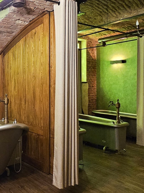Luxurious spa bath tubs in a rustic brick and wood interior setting.