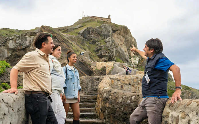 Tour group exploring San Juan de Gaztelugatxe islet, Basque Country, known as "Dragonstone" in Game of Thrones.
