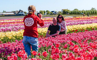 Guests posing in colorful tulip fields during the Tulip Experience tour at Keukenhof.